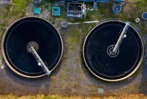 Aerial view of waste water treatment works with water tanks full of dirty water