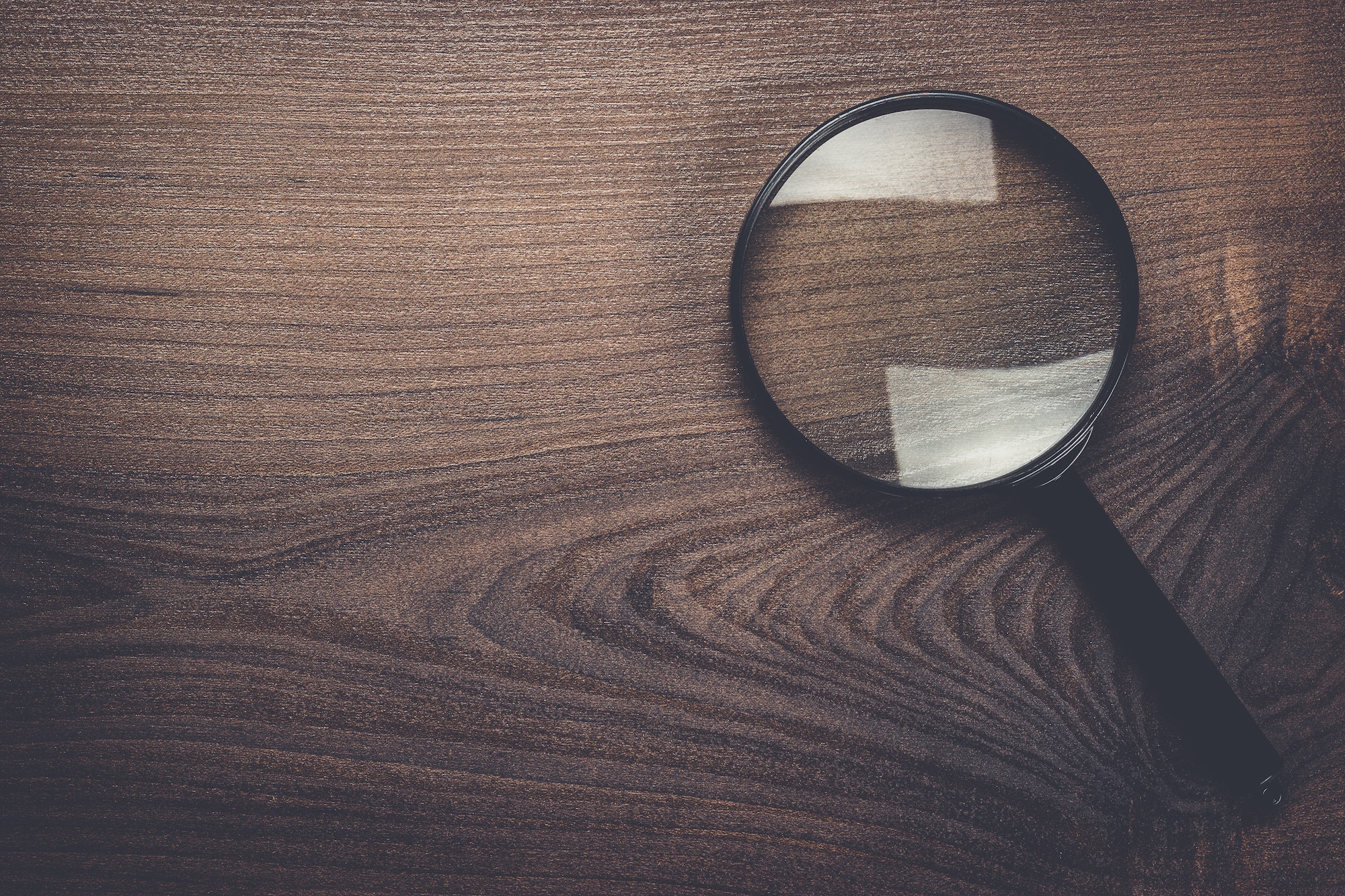 magnifying glass on wooden background